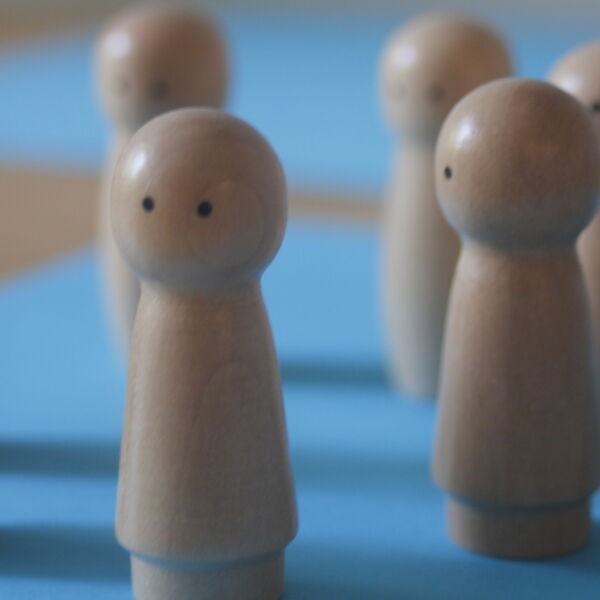 Holzfiguren symbolisieren eine Gruppentherapie-Situation